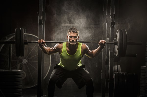 Caucasian man lifting barbell in gymnasium