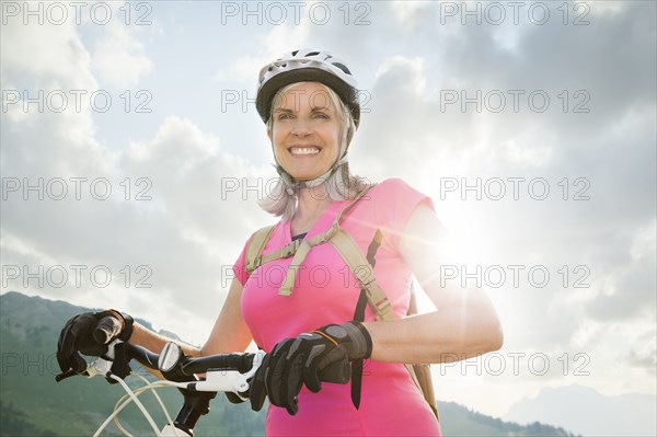 Caucasian woman standing with mountain bike