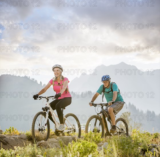 Caucasian couple riding mountain bikes