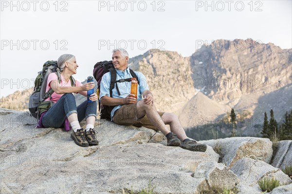 Caucasian couple resting on mountain