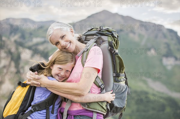 Caucasian grandmother hugging granddaughter on mountain