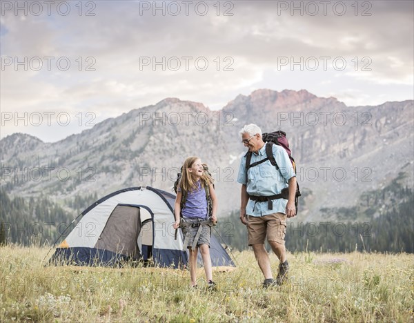 Caucasian grandfather and granddaughter camping on mountain