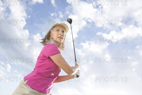 Caucasian woman swinging golf club