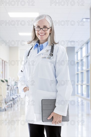 Portrait of smiling Caucasian doctor holding digital tablet