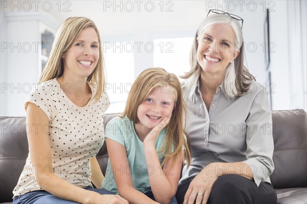 Portrait of women and girl sitting on sofa