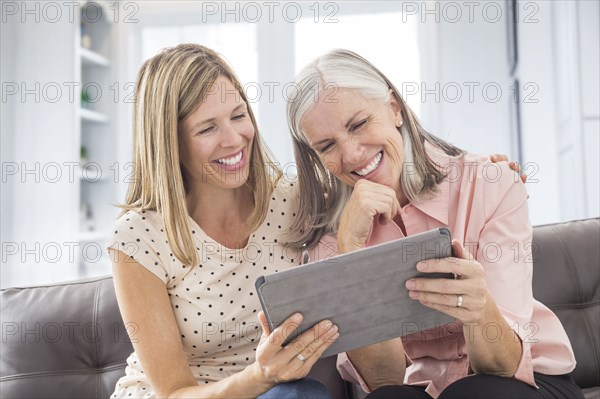Smiling Caucasian women using digital tablet