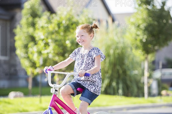 Caucasian girl riding bicycle