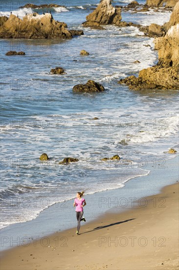 Caucasian woman running on beach