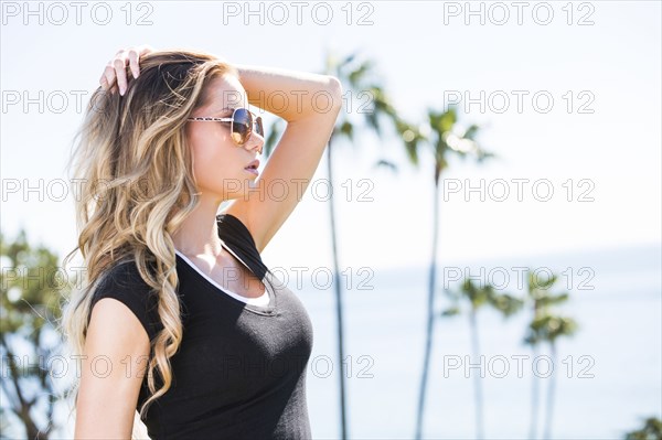 Caucasian woman with hand in hair near ocean