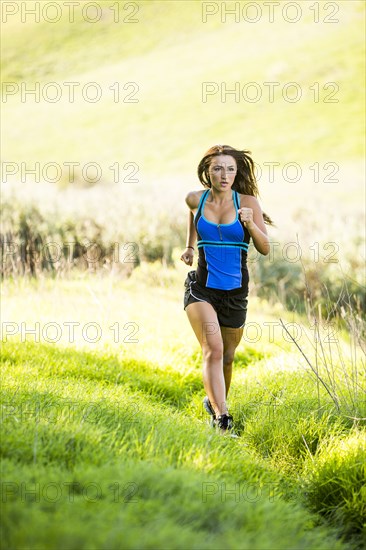 Caucasian woman running on hill