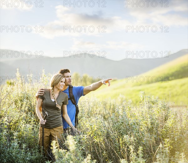 Caucasian couple hiking on hill