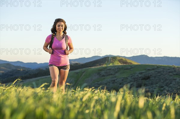 Asian woman hiking on hill