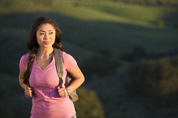 Asian woman hiking on hill