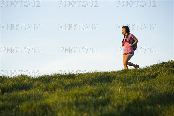 Asian woman hiking on hill