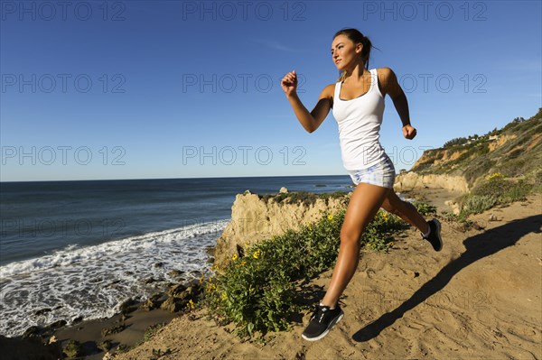 Caucasian woman running on beach