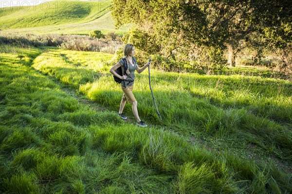 Caucasian woman hiking on hill