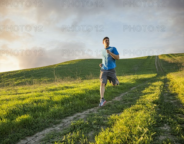 Hispanic man running on hill