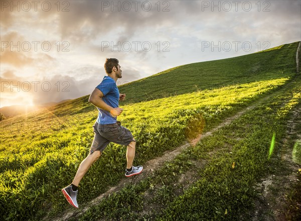 Hispanic man running on hill