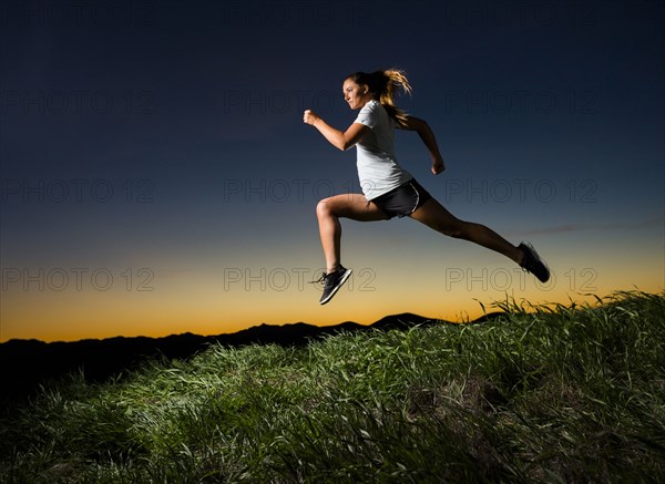 Caucasian woman running at sunset