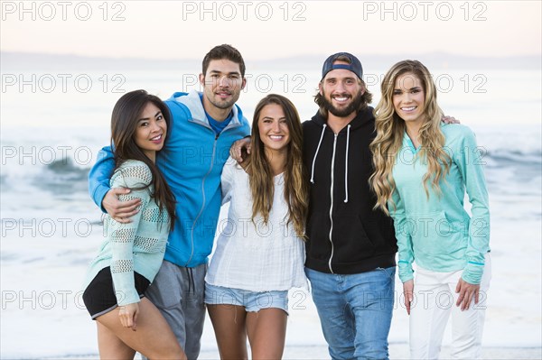 Smiling friends posing at beach