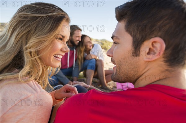 Smiling friends relaxing at beach