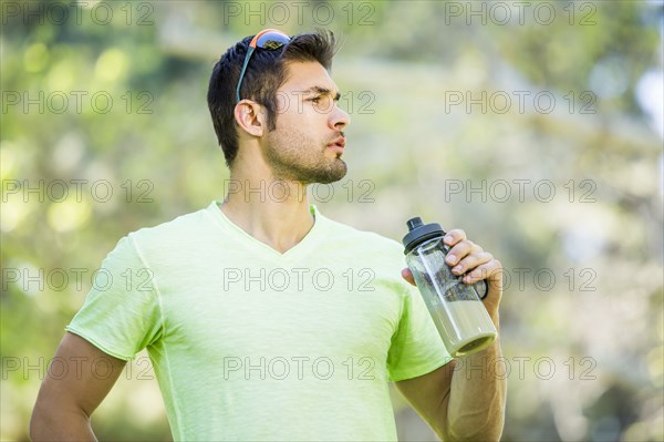 Hispanic man drinking smoothie outdoors