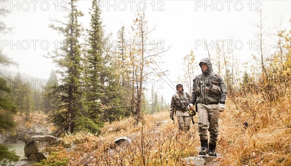 Caucasian men carrying fishing rods