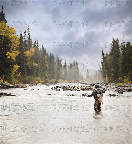 Caucasian man fishing in river