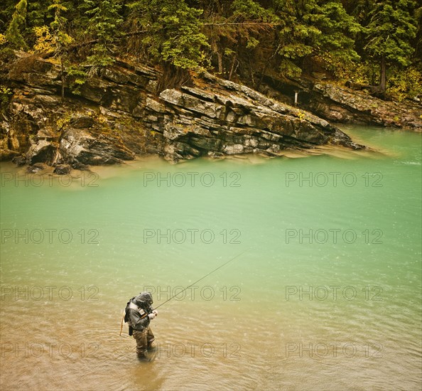 Caucasian man fishing in river