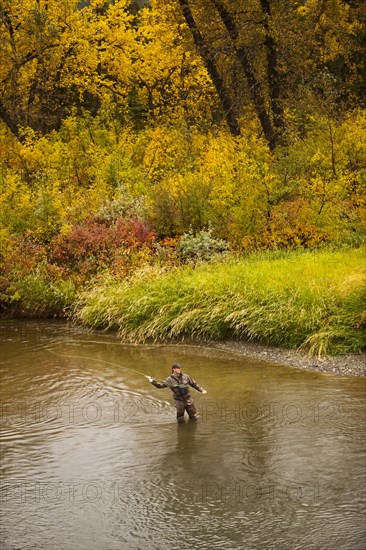 Caucasian man casting in river