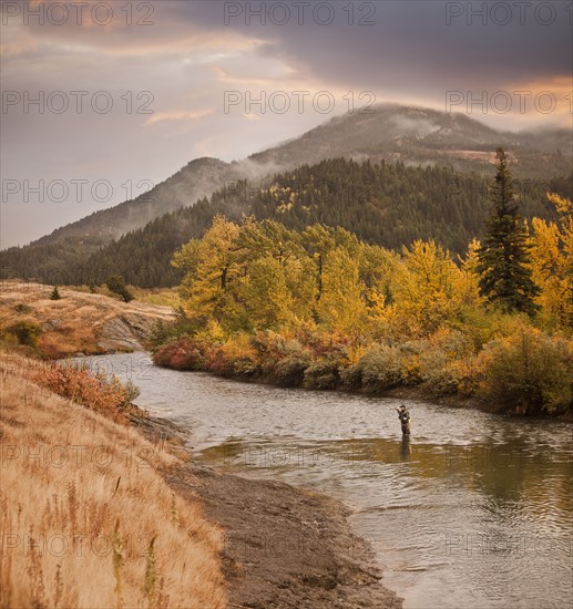 Caucasian man fishing in river