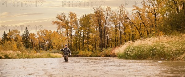 Caucasian man fishing in river