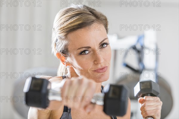 Woman lifting weights in gymnasium