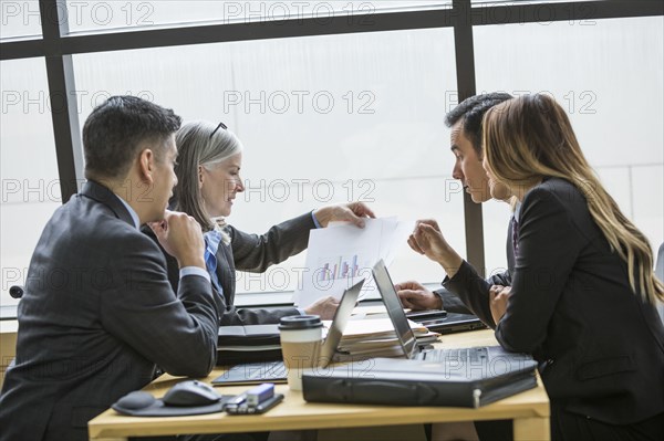 Business people examining chart in meeting