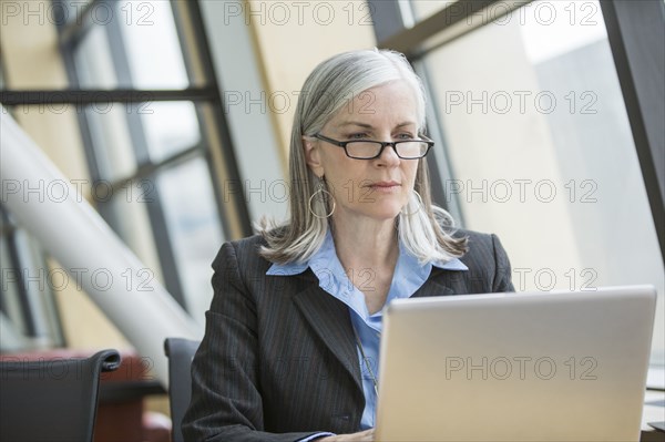Serious Caucasian businesswoman using laptop