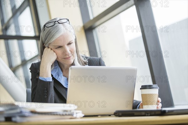 Frustrated Caucasian businesswoman using laptop