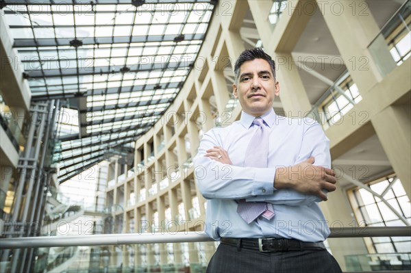 Serious Mixed Race businessman posing in lobby