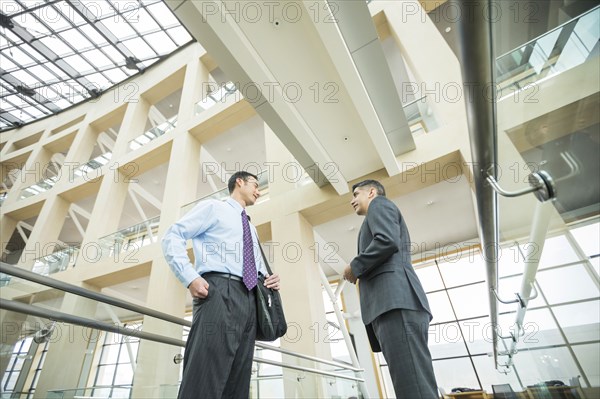 Smiling businessmen talking in lobby