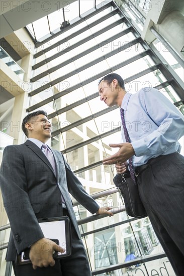 Smiling businessmen talking in lobby