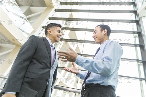 Smiling businessmen talking in lobby