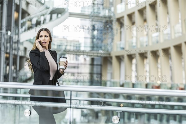 Mixed Race businesswoman talking on cell phone in lobby