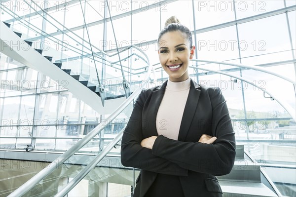 Portrait of smiling Mixed Race businesswoman standing on staircase