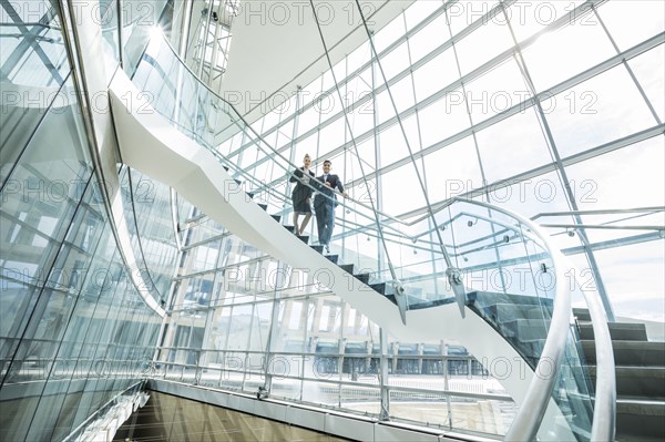 Portrait of distant Mixed Race business people standing on staircase