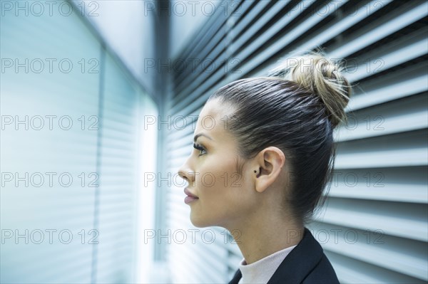 Profile of serious Mixed Race businesswoman in corridor