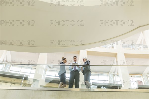 Business people using digital tablet in lobby