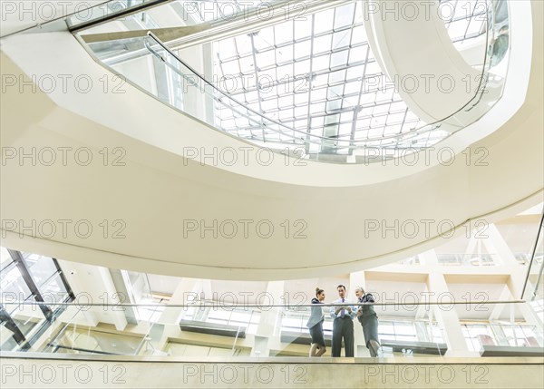 Business people using digital tablet in lobby