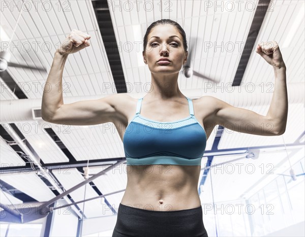 Caucasian woman flexing arm muscles