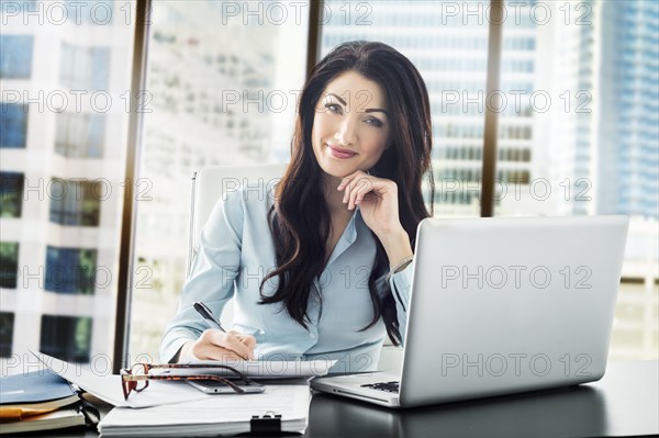 Caucasian businesswoman writing on paperwork