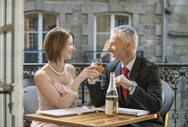 Well-dressed Caucasian couple toasting with champagne