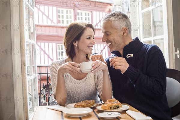 Caucasian couple drinking coffee at breakfast